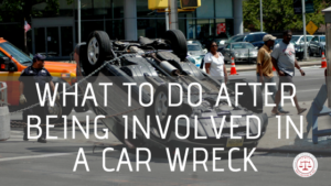 What to Do After Being Involved in a Car Wreck, Car flipped over on road with people walking by