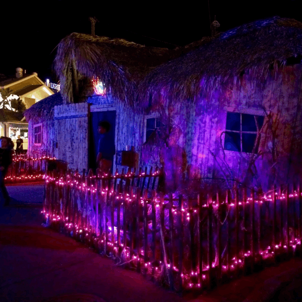 Haunted house with glowing purple lights at night, featured in Halloween events in Houston 2025.