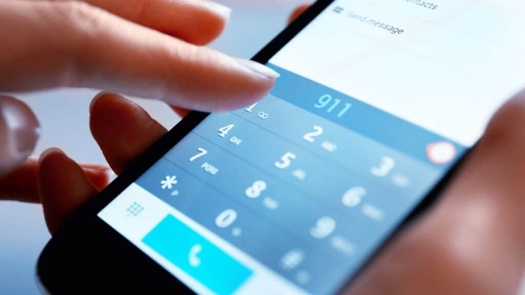 Person dialing 911 on a smartphone after a delivery truck accident Houston, highlighting steps recommended by Attorney Don McClure, Personal Injury Attorney in Houston.