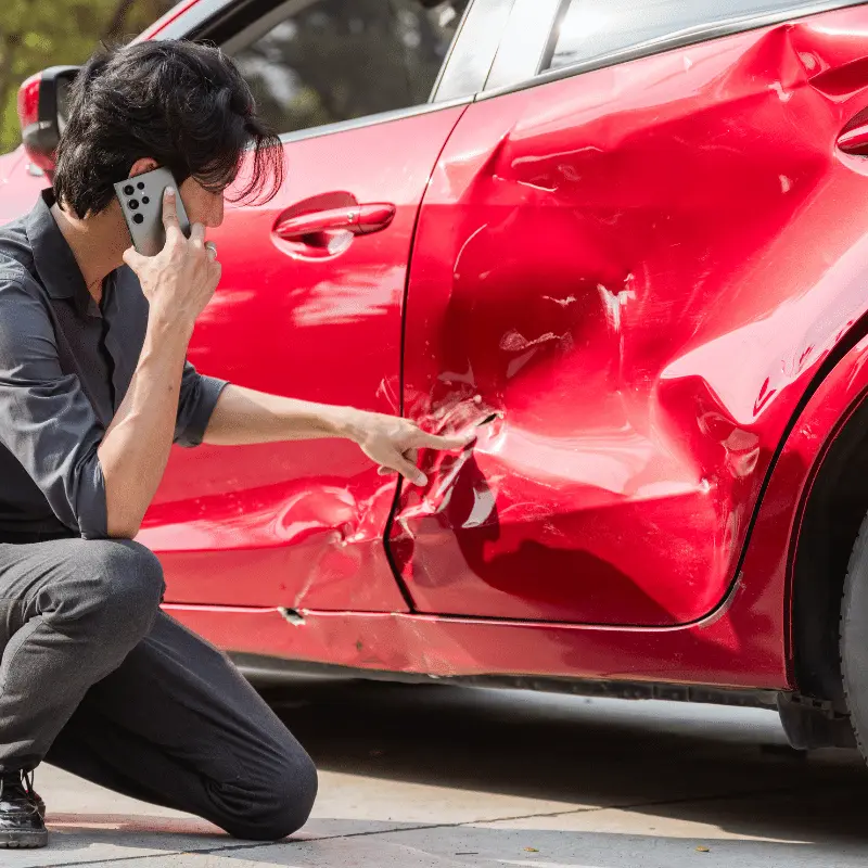 Two cars involved in a rear-end collision under a Pasadena, Texas street sign, showing vehicle damage on a busy road.