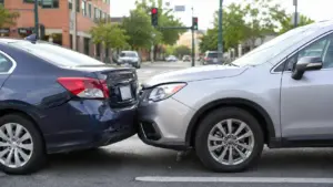 Minor fender bender car accident in Texas showing two vehicles with light bumper damage at an urban intersection.